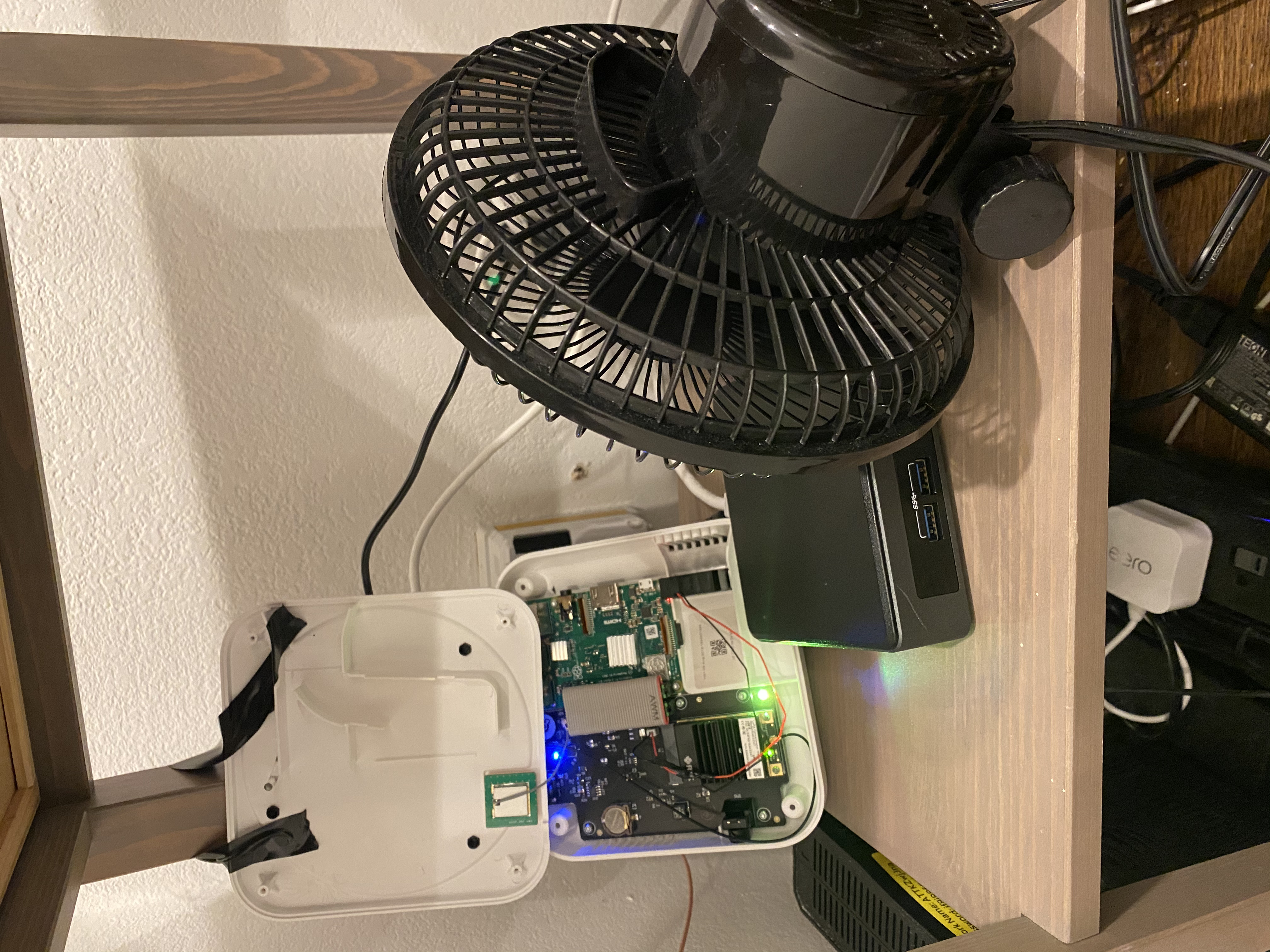 An exposed circuit board with a table-top fan blowing it