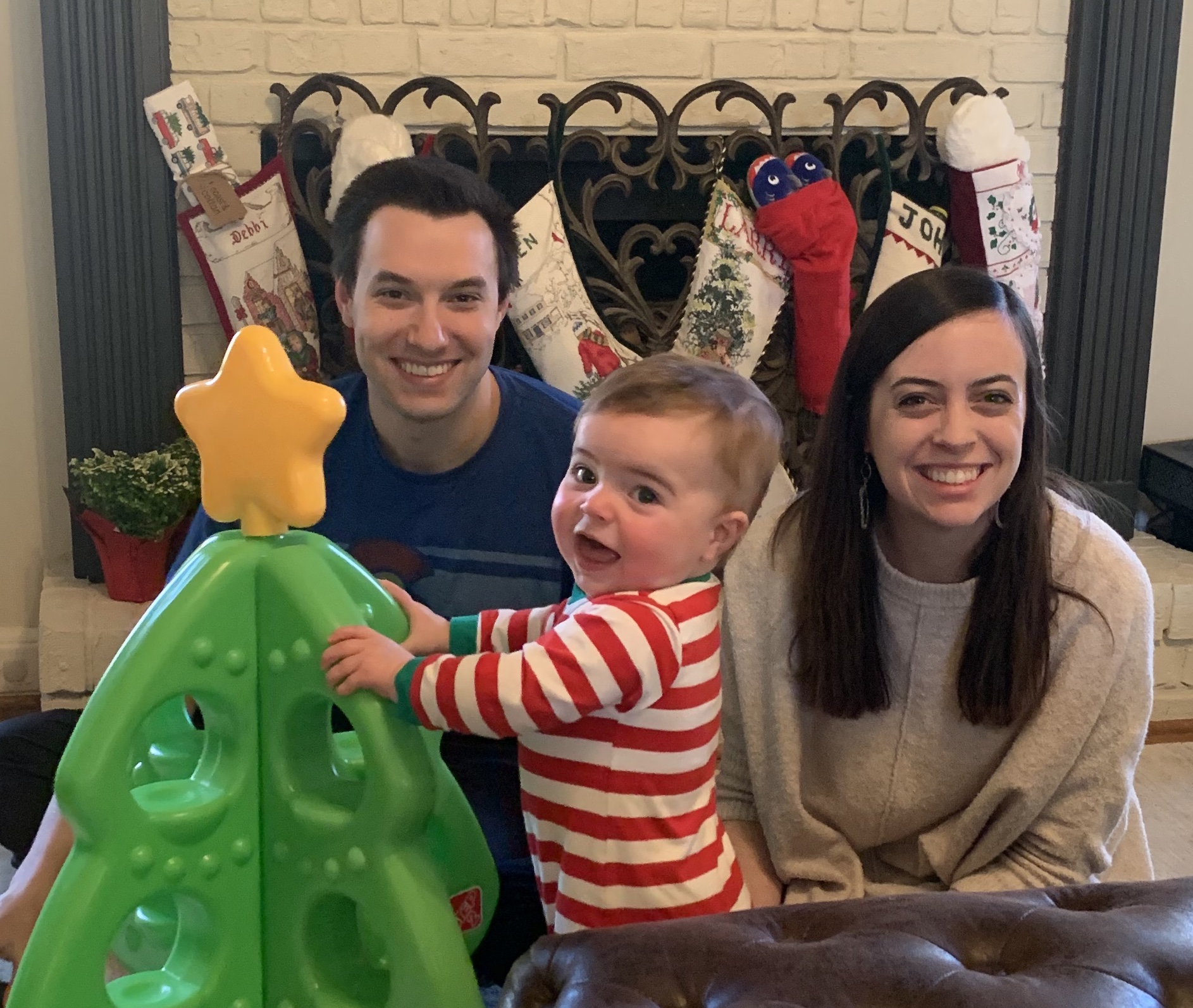 Me, my wife, and my 1-yr old son, sitting in front of a plastic Christmas tree, looking very cute.